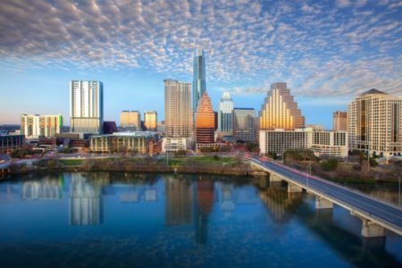 The Austin Skyline in Austin, Texas, shines on a late afternoon. The iconic Austin highrises are reflected in Lady Bird Lake.